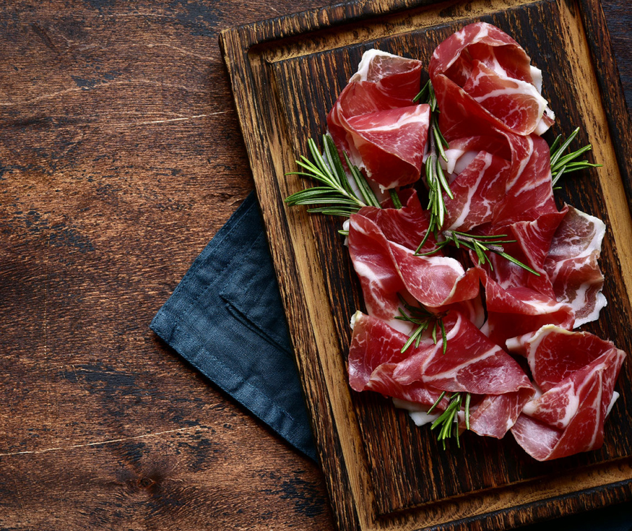 Slices of prosciutto di parma or jamon serrano (iberico) . Top view with copy space.